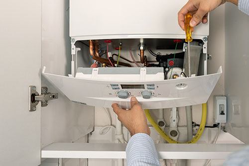 HVAC technician repairing an indoor boiler in Pueblo