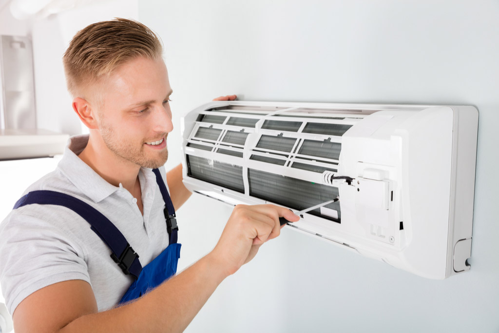 HVAC technician performing ductless air conditioning maintenance in Pueblo