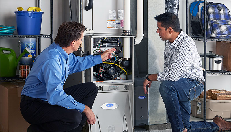 HVAC technician evaluating a furnace for repair or replacement in Pueblo