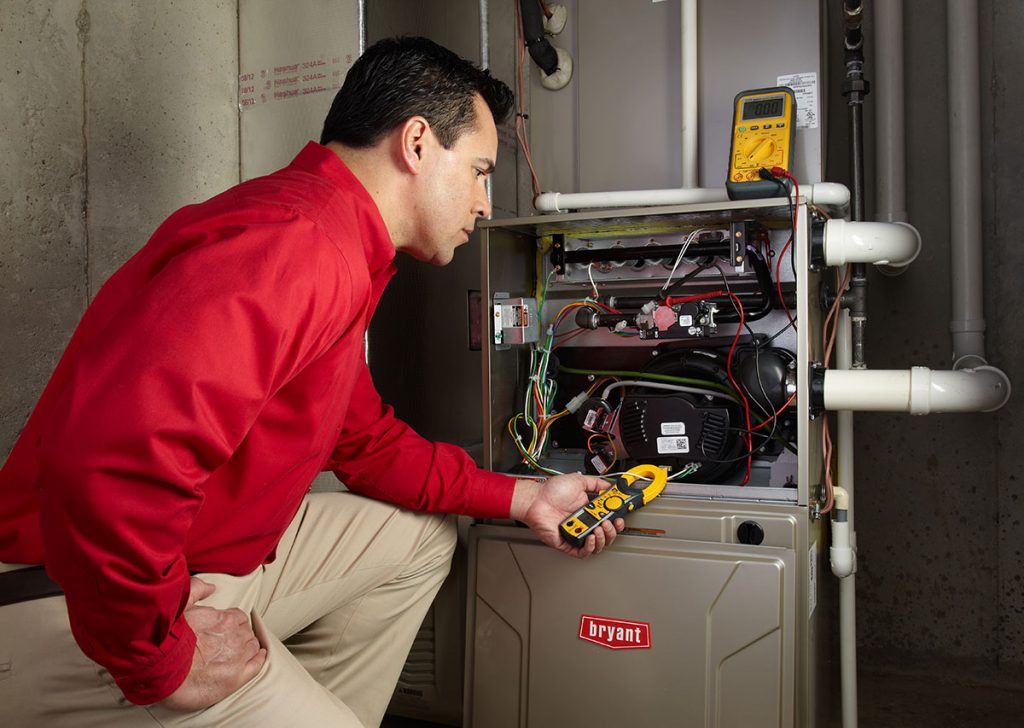 HVAC technician repairing an indoor furnace in Pueblo
