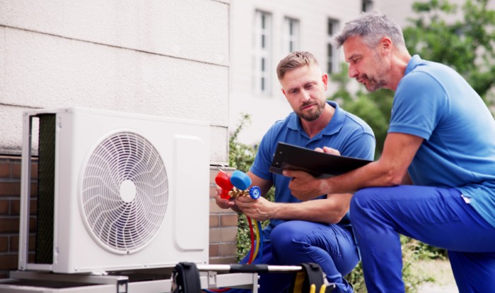 HVAC technicians installing an outdoor air conditioning unit in Pueblo