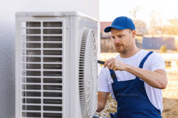 HVAC technician servicing an outdoor air conditioning unit in Pueblo
