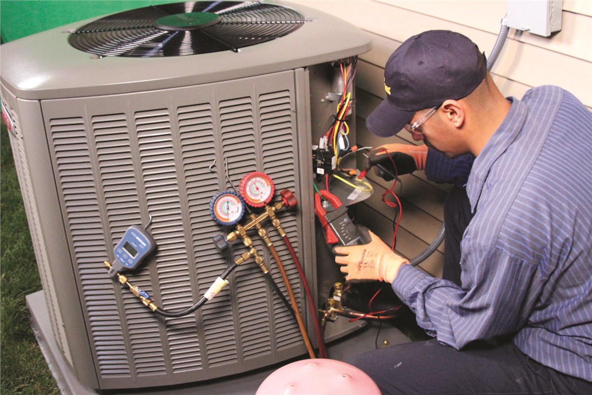 HVAC technician testing an outdoor air conditioning unit in Pueblo