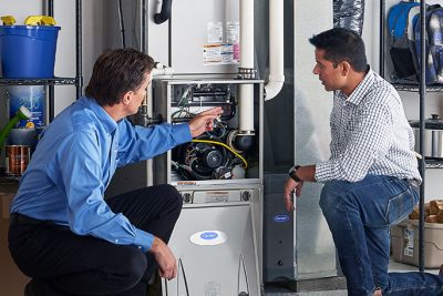 HVAC technician explaining furnace repair and maintenance to a homeowner in Pueblo, CO