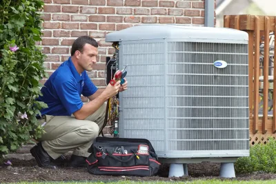 HVAC technician inspecting an outdoor air conditioning unit in Pueblo, CO