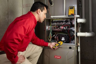 Heating and air conditioning technician servicing an indoor furnace in Pueblo, CO